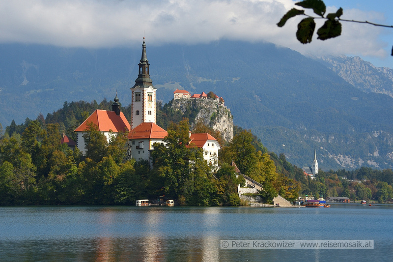 Slowenien, am Bleder See, Blick zur Marieninsel mit Kirche, dahinter die Burg von Bled.
